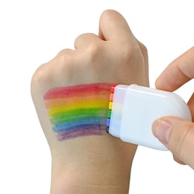 person using rainbow face paint highlighter on hand