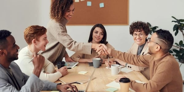 group of people shaking hands at a conference table