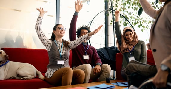 muti racial group of businesspeople playing a game and raising hands