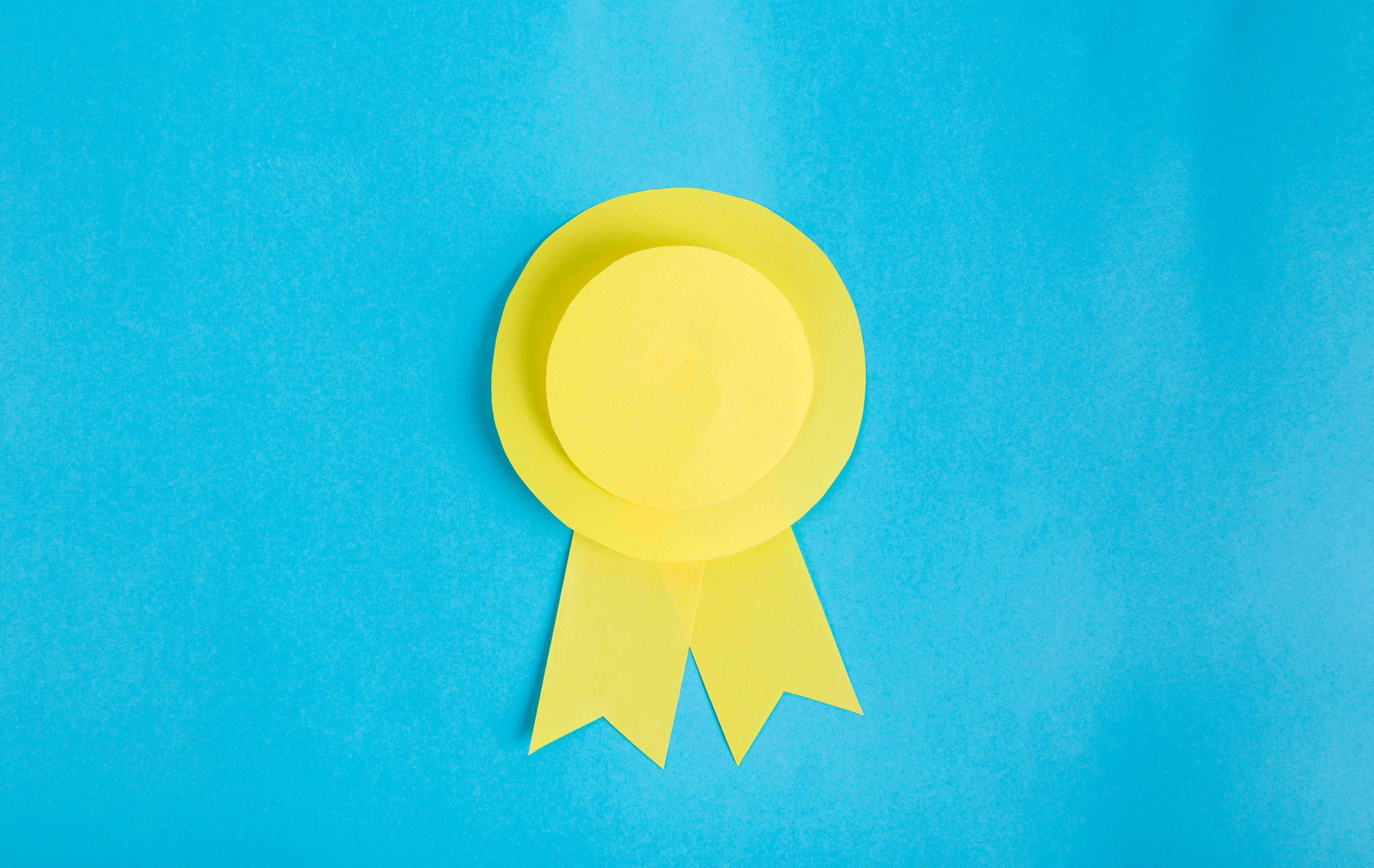 yellow paper made into a ribbon on light blue background