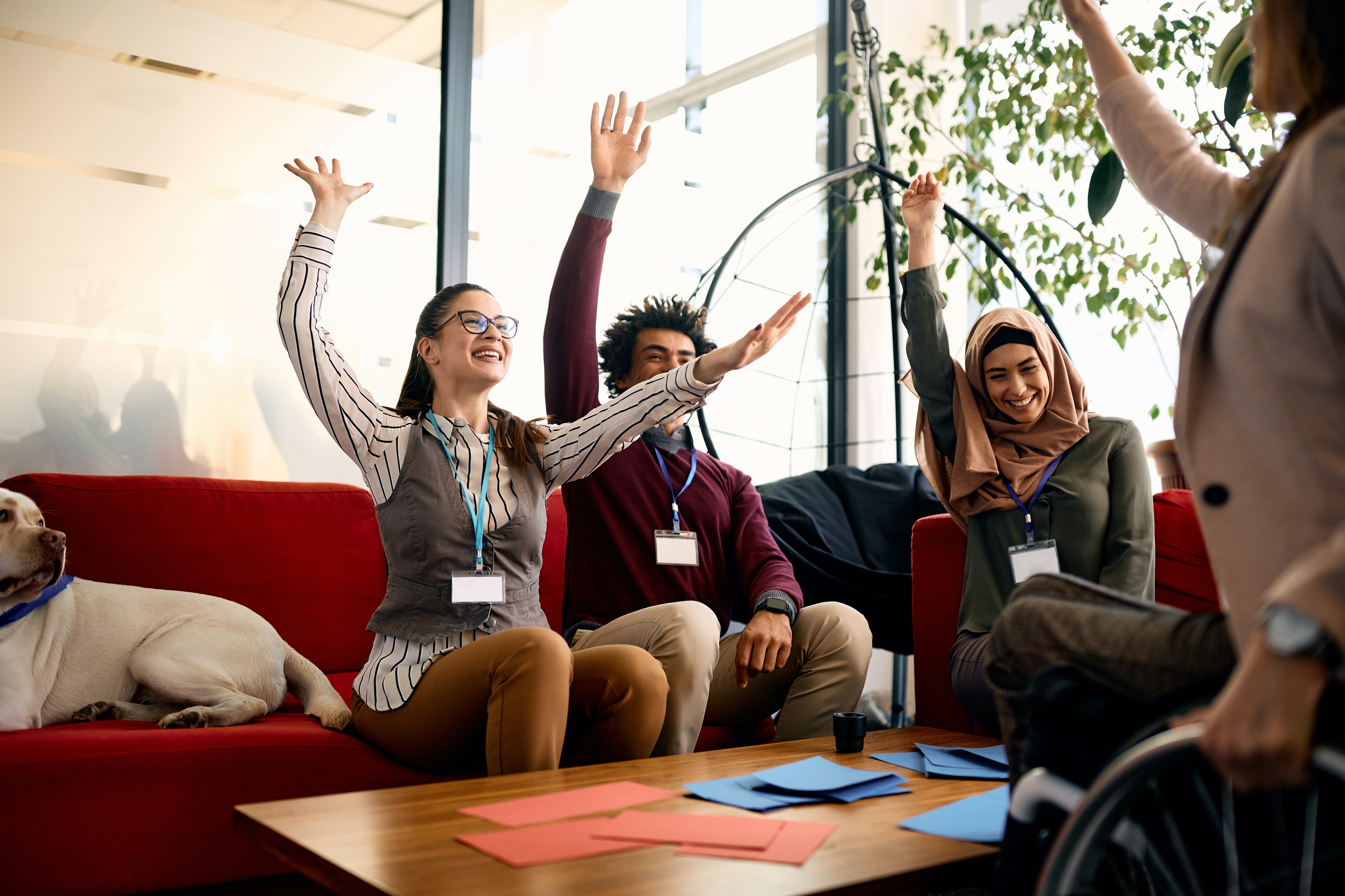 mixed group of businesspeople playing a game and raising hands