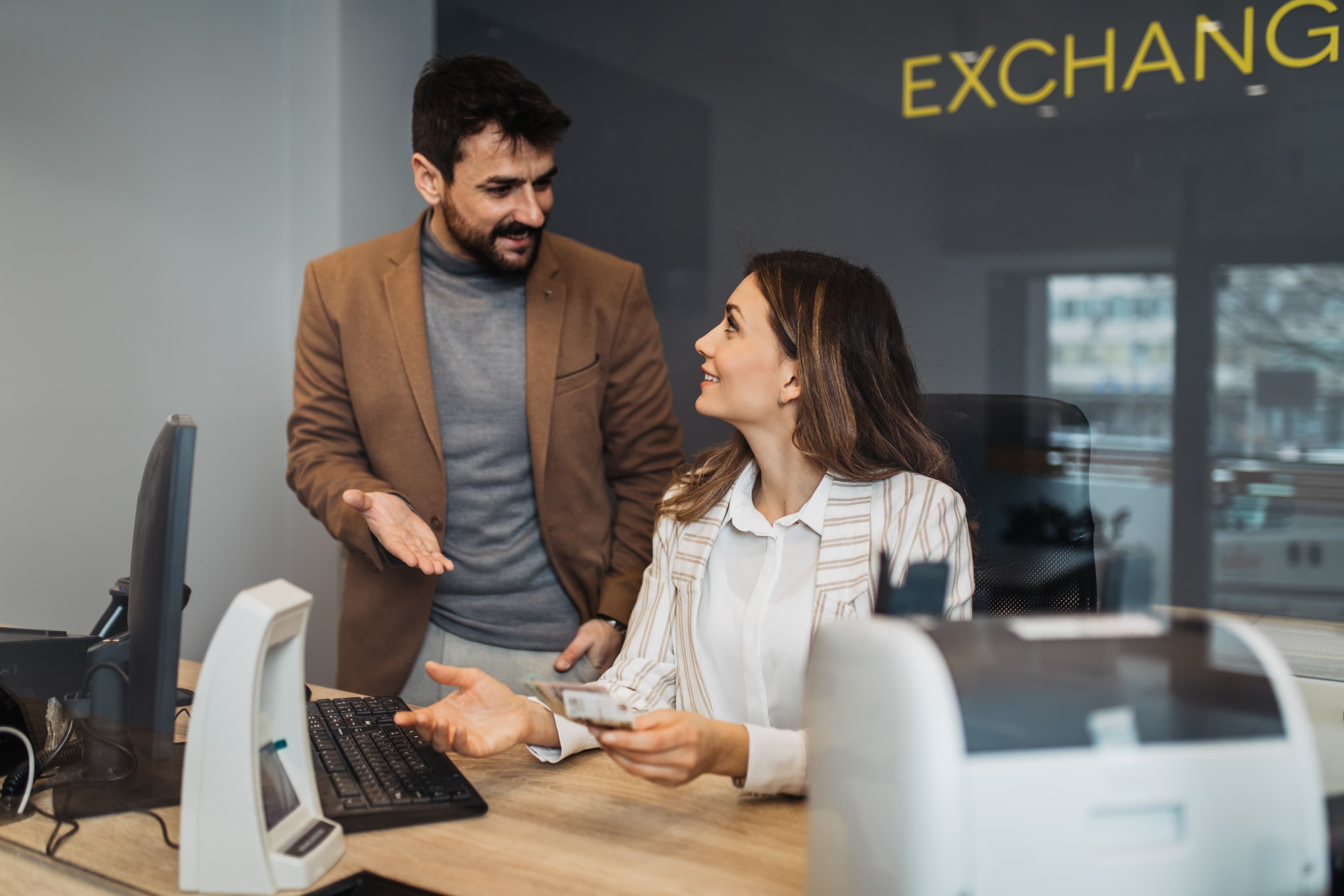 two people at a money exchange - Why Financial Enterprises Need a Company Store blog cover image