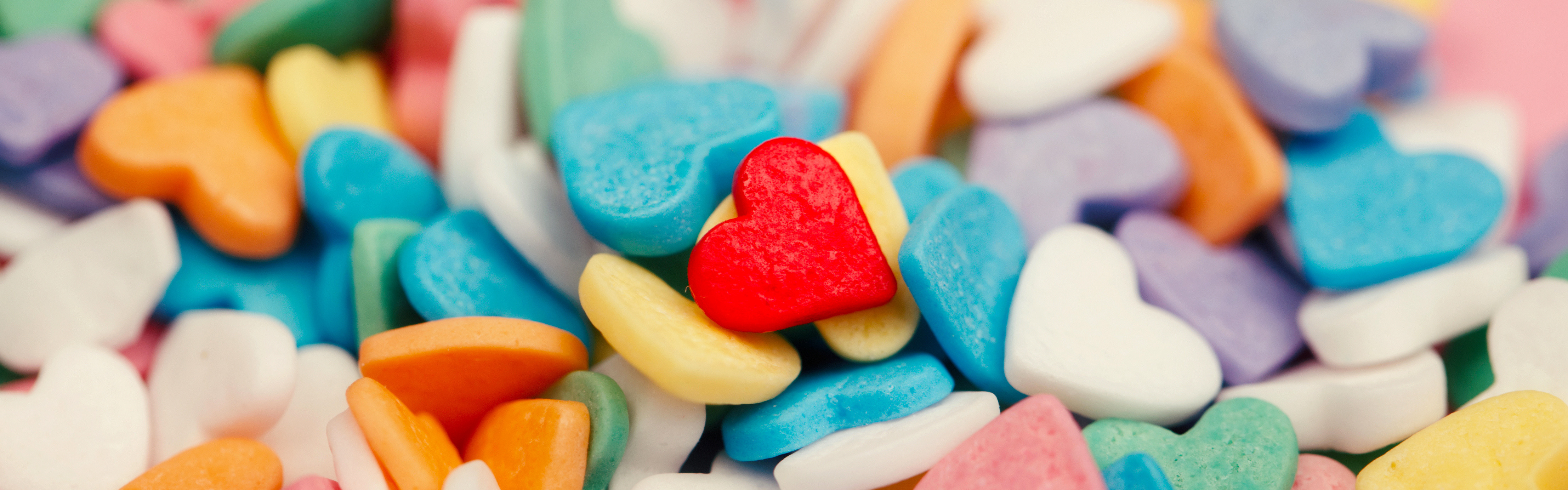 multi-colored candy hearts in a pile